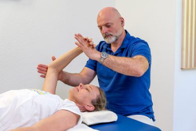 Patientin auf Liege wird von Thorsten Schmidt behandelt